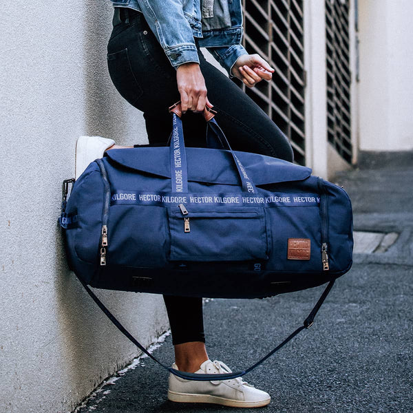 Women with navy blue duffle travel bag in city
