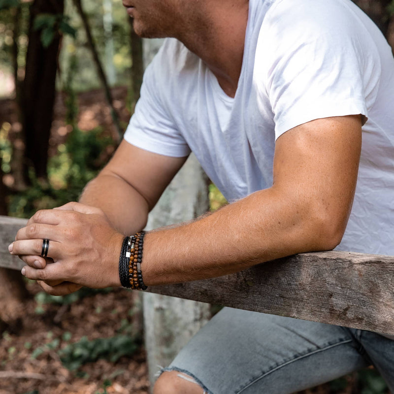 Man wearing black and silver tungsten ring and leather and beaded bracelets